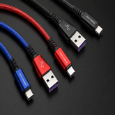 Three braided USB-C charging cables in blue, red, and black, arranged diagonally on a dark background. Each cable has a USB-A connector on one end and a USB-C connector on the other, with 'FAST CHARGE' printed on the metal connector housing.