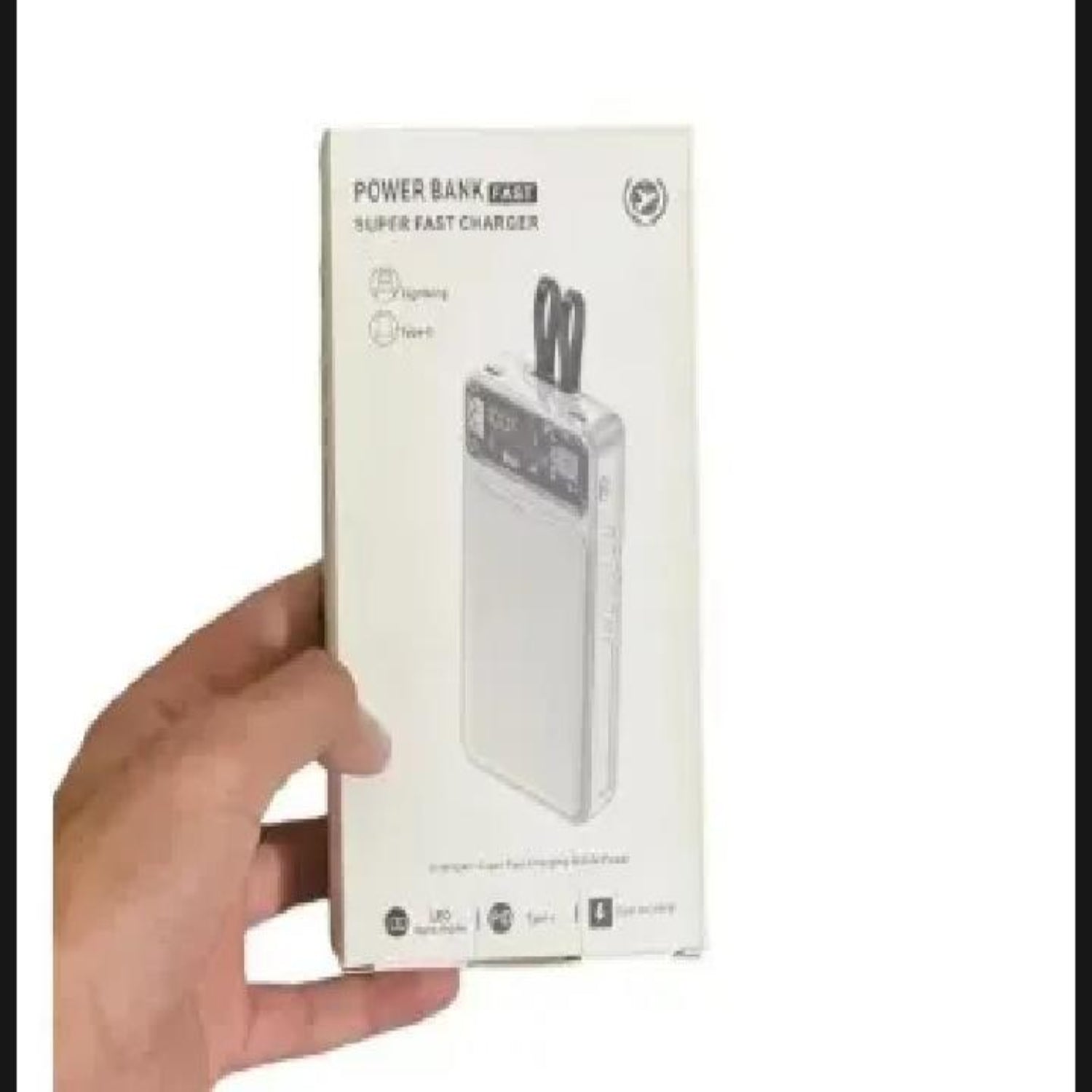 Hand holding a power bank packaging box on a white background.